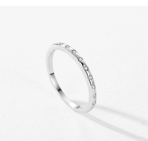 Dettaglio macro di un anello minimalista in argento S925 con fascia di micro diamanti