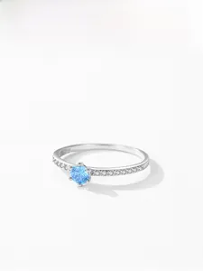 Detailed close-up of S925 sterling silver ring with blue zircon and pavé-set side stones