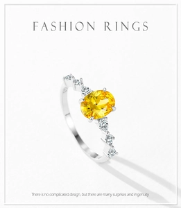 Macro shot of oval yellow zircon ring with silver band and side-stone pavé details