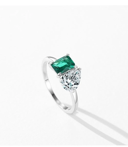 Détail d'une émeraude verte et d'un zircon poire sur un anneau en argent S925 poli