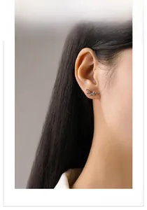 Gros plan de boucles d'oreilles en argent S925 avec zirconiums arc-en-ciel sur modèle