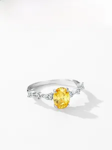 Macro shot of S925 silver ring featuring oval yellow zircon and pear-shaped side stones