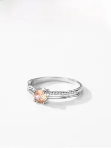Gros plan sur la bague en zircon champagne avec serti à griffes et anneau pavé