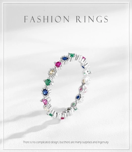 Macro detail of colorful round zircon gemstones on a silver band with bead edge texture