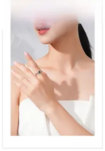 Detail view of a model wearing a sterling silver ring with a rectangular emerald zircon