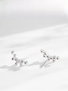 Vue macro de boucles d'oreilles vagues en argent S925 avec zircones colorées serties
