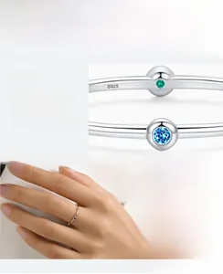 Macro detail of S925 silver ring featuring blue and green cubic zirconia stones