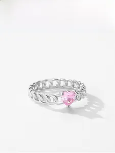 Détail macro d'une bague chaîne en argent avec un cristal rose en forme de coeur
