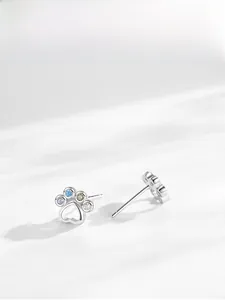 Macro shot of S925 silver paw studs featuring rainbow cubic zirconia and heart cutouts