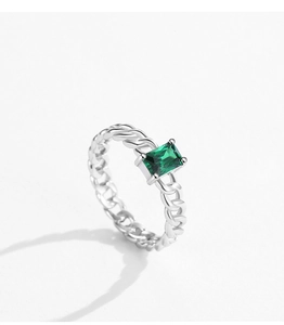 Macro detail of silver twisted rope ring band with emerald-cut green gemstone setting