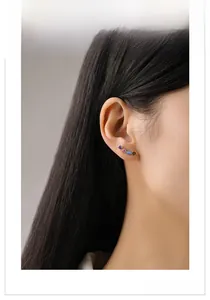 On-ear view of colorful teardrop zircon climber earrings with gold-plated finish