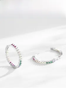 Macro detail of S925 sterling silver hoop earrings with rainbow cubic zirconia stones
