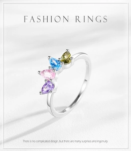 Macro detail of crown ring with four colorful pear-cut zircons in silver setting