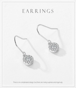 Détail de boucles d'oreilles halo en argent 925 avec une pierre centrale de taille brillant
