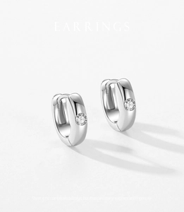 Detail of polished S925 silver hoop earrings featuring a centered round cubic zirconia