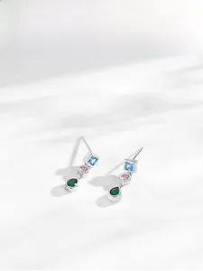 Macro detail of S925 silver drop earrings with square, round, and pear-shaped gemstones
