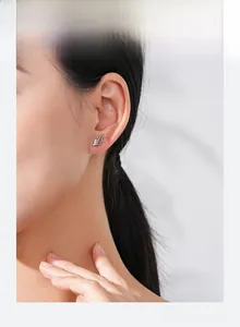 Detail view of S925 sterling silver angel wing stud earrings with pavé crystals on ear