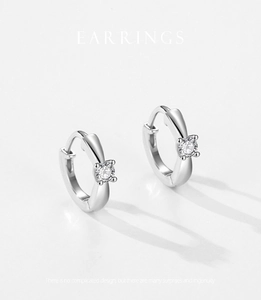 Macro detail of silver S925 hoop earrings with sparkling round-cut zircon stones