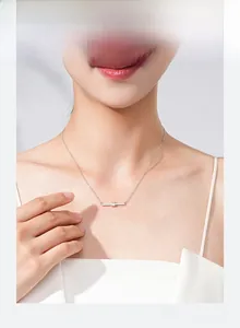 Close-up of S925 silver bar necklace with pavé diamonds worn by a model on collarbone