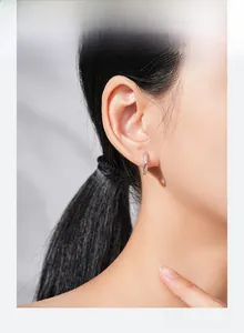 Détail de créoles torsadées en argent S925 avec cristaux pavés sur l'oreille