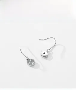 Détail de boucles d'oreilles en argent sterling avec pendentif rond serti de zircons
