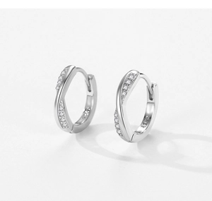 Détail macro de créoles en argent S925 avec pavage de zircones et design croisé chic