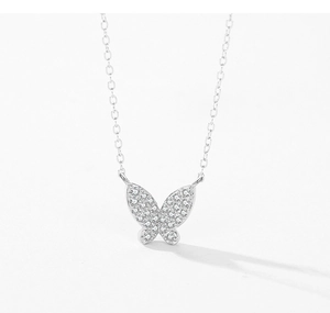 Macro detail of silver butterfly pendant with micro-pave sparkling white gemstones