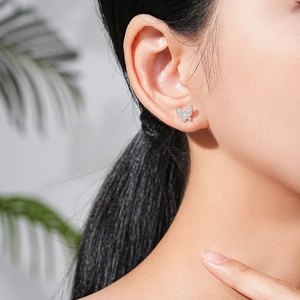 Boucles d'oreilles papillon en argent S925 avec zircons brillants portées par un modèle