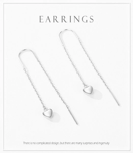 Detail of silver S925 heart threader earrings with delicate long tassel chains