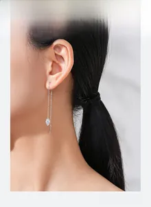 Gros plan de longues boucles d'oreilles pampilles en argent sur un mannequin