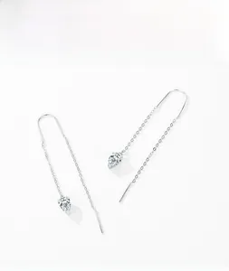Détail de boucles d'oreilles longues en argent avec zircons clairs de taille poire