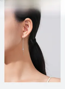 Close-up of minimalist S925 sterling silver long threader earring with geometric charms