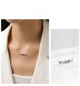 Detail of silver necklace featuring five multicolor geometric zircons on model and white background