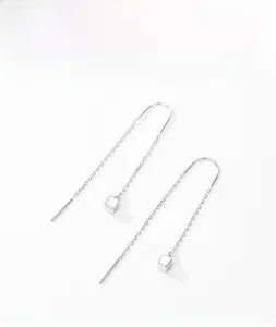 Macro shot of S925 sterling silver threader earrings with minimalist cube geometric charms