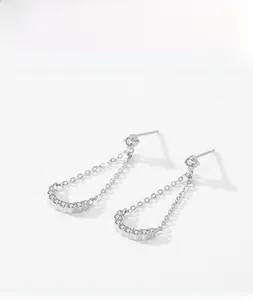 Detail of silver tassel earrings with geometric U-shape pendant and white cubic zirconia