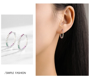 Close-up of S925 silver earrings with colorful zircon stones and a model ear shot