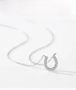 Détail macro du pendentif en fer à cheval en argent avec zircons brillants et chaîne fine