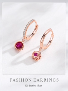 Macro detail of S925 silver hoop earrings with red zircon and honeycomb hollow back