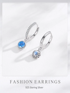 Detail of S925 sterling silver hoop earrings with blue stone and hollow floral backing