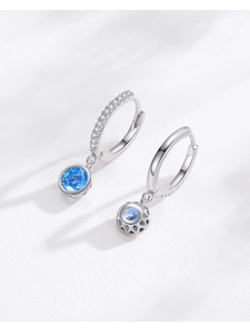 Vue macro détaillée des boucles d'oreilles en argent S925 avec zircon bleu et pendentif