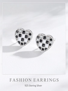 Détail macro de boucles d'oreilles cœur en argent 925 avec damier en émail et oxydes de zirconium