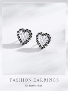 Gros plan d'une boucle d'oreille cœur en argent S925 avec zircon noir et motif matelassé
