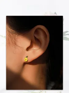 Detail of S925 silver lemon enamel stud earring worn by model showing actual size