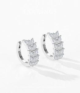 Détail de boucles d'oreilles en argent S925 serties de zircons marquise sur fond blanc