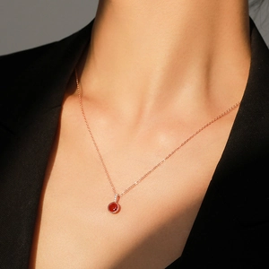 Collier en argent S925 or rose avec pendentif rubis rouge rond porté par une femme