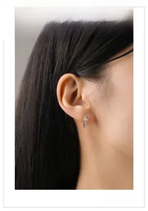 Détail de boucles d'oreilles en argent 925 avec zircons portées par un mannequin