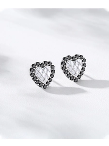 Détail de boucles d'oreilles cœur en argent S925 avec zircon noir et motif matelassé