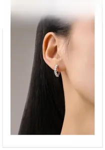 Gros plan de boucles d'oreilles créoles S925 en argent avec zircons sur le profil du mannequin
