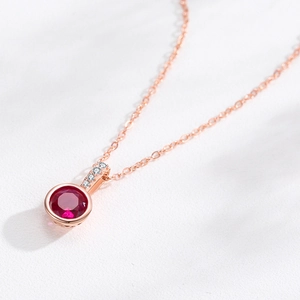 Élégant collier en or rose avec pendentif pierre précieuse rouge ronde et petites pierres