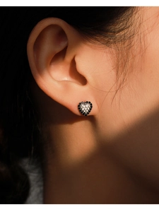 Vue macro des boucles d'oreilles cœur en argent S925 avec zircons noirs et matelassage